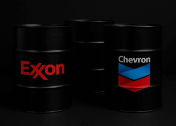 Barriles de petróleo Exxon y Chevron sobre fondo oscuro Exxon